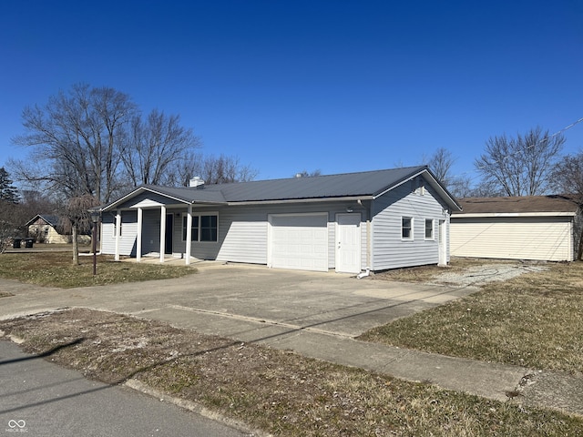 view of front of home with concrete driveway, an attached garage, and metal roof