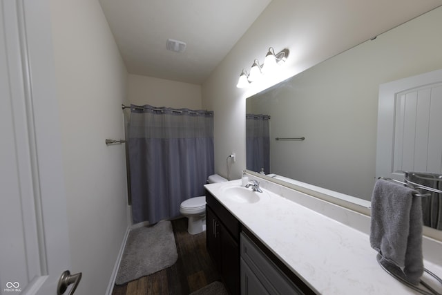 bathroom with visible vents, toilet, a shower with shower curtain, wood finished floors, and vanity