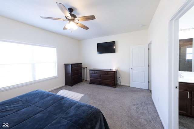 carpeted bedroom with a sink, baseboards, and a ceiling fan