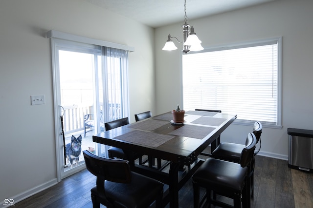 dining room featuring a healthy amount of sunlight, dark wood-type flooring, and baseboards