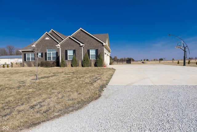 view of front of house featuring brick siding, driveway, an attached garage, and a front lawn