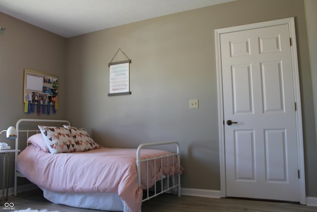 bedroom featuring baseboards and wood finished floors