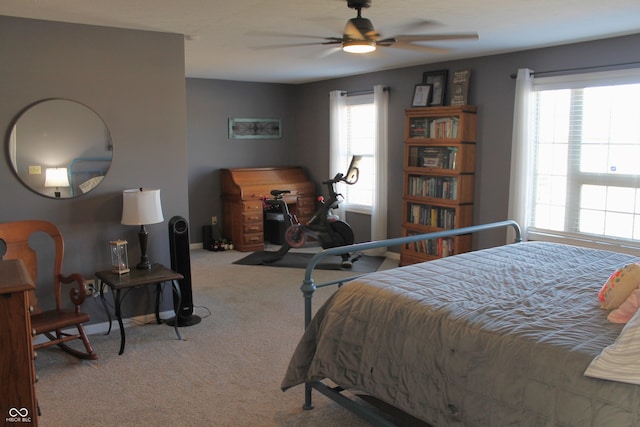 carpeted bedroom featuring ceiling fan, multiple windows, and baseboards