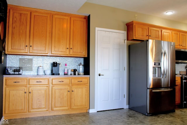 kitchen with appliances with stainless steel finishes, decorative backsplash, and light countertops