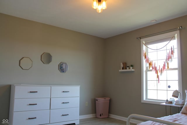 bedroom with light wood-style flooring and baseboards