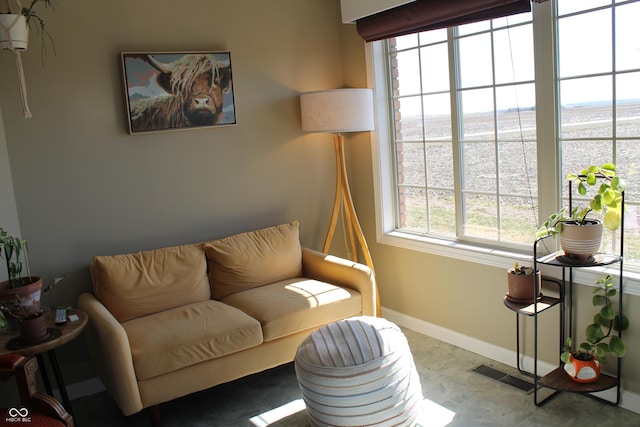 living area featuring baseboards and visible vents