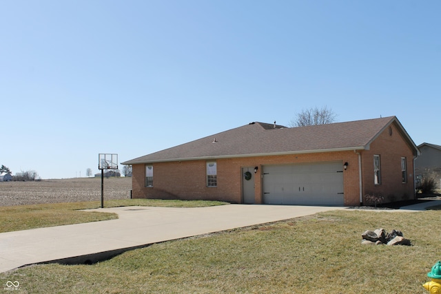 view of side of property featuring a yard, brick siding, driveway, and an attached garage