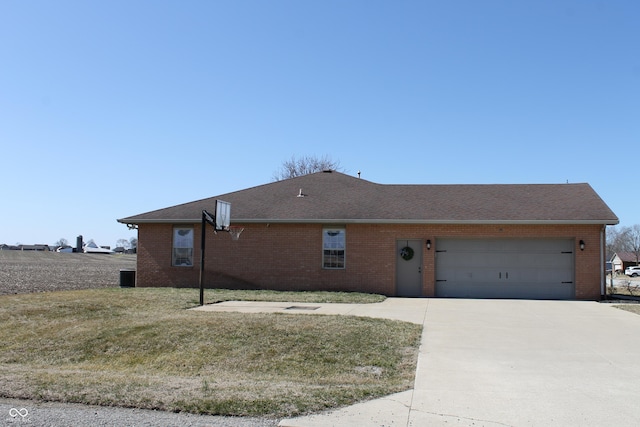 exterior space with a garage, a front yard, brick siding, and driveway