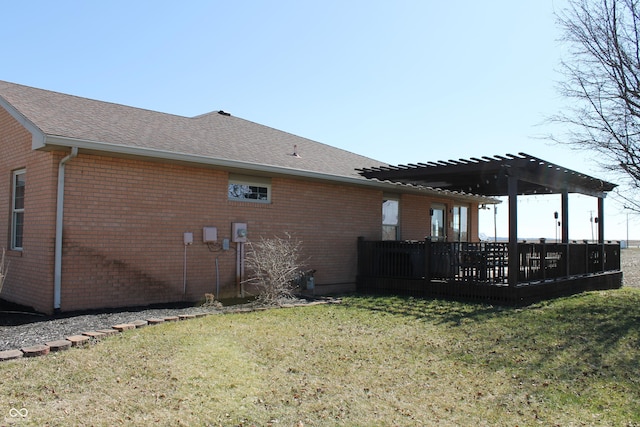 view of side of property featuring roof with shingles, brick siding, a lawn, and a pergola