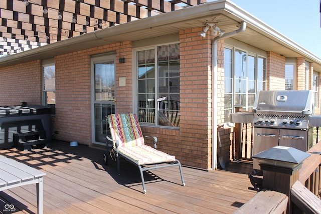 wooden terrace with area for grilling and a pergola