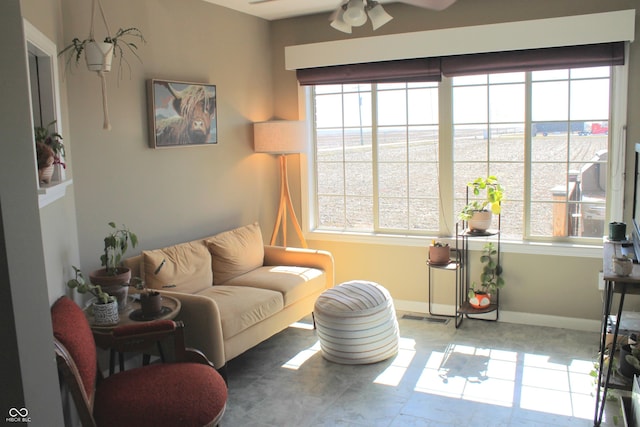 living room with ceiling fan, visible vents, and baseboards