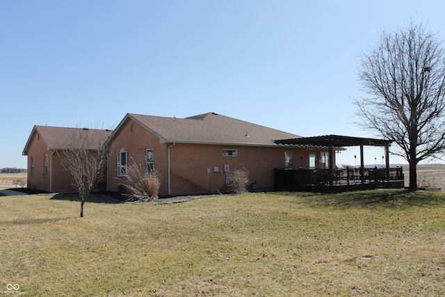 view of home's exterior with a yard, brick siding, roof with shingles, and a pergola