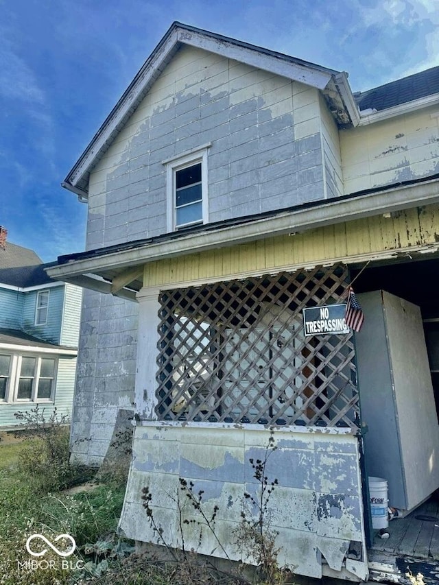 view of side of home featuring covered porch