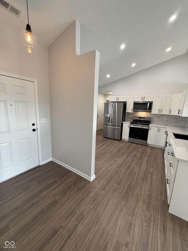 kitchen with lofted ceiling, visible vents, white cabinets, light countertops, and appliances with stainless steel finishes