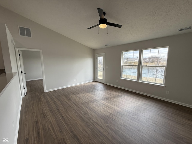 spare room featuring baseboards, visible vents, vaulted ceiling, and dark wood-type flooring