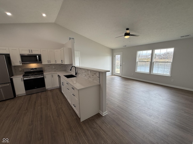 kitchen featuring tasteful backsplash, light countertops, visible vents, appliances with stainless steel finishes, and open floor plan