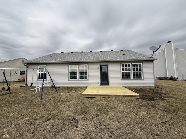 back of property featuring a shingled roof, a lawn, and a wooden deck