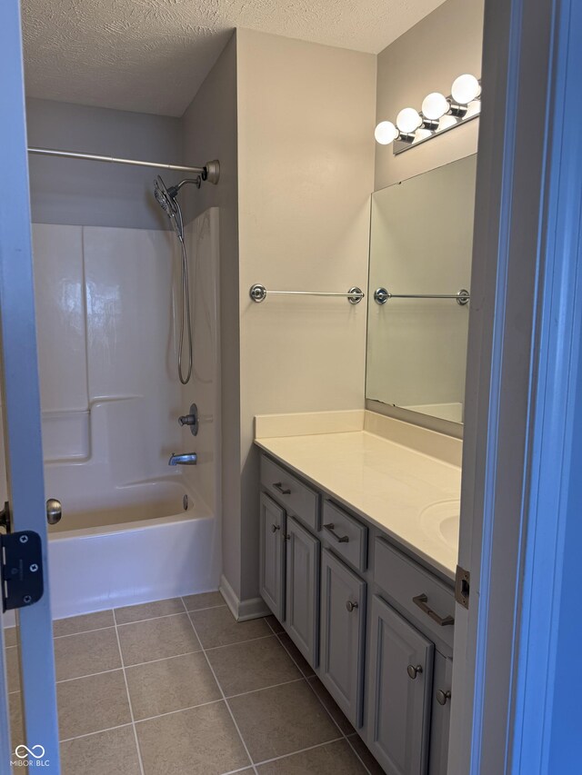 full bath featuring vanity, tile patterned floors, tub / shower combination, and a textured ceiling