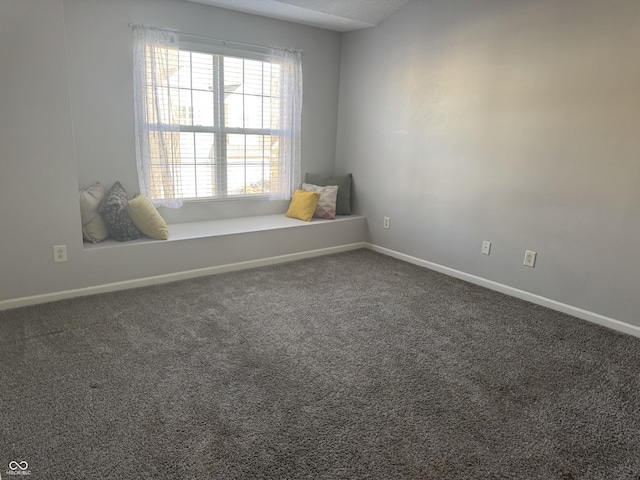 carpeted empty room featuring baseboards