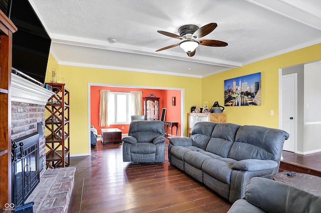 living area featuring dark wood-type flooring, ceiling fan, beam ceiling, a fireplace, and a textured ceiling