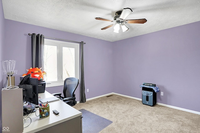 carpeted office with baseboards, a textured ceiling, and a ceiling fan