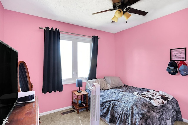 bedroom featuring baseboards, carpet, a ceiling fan, and a textured ceiling