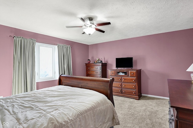 bedroom with carpet flooring, a ceiling fan, baseboards, and a textured ceiling