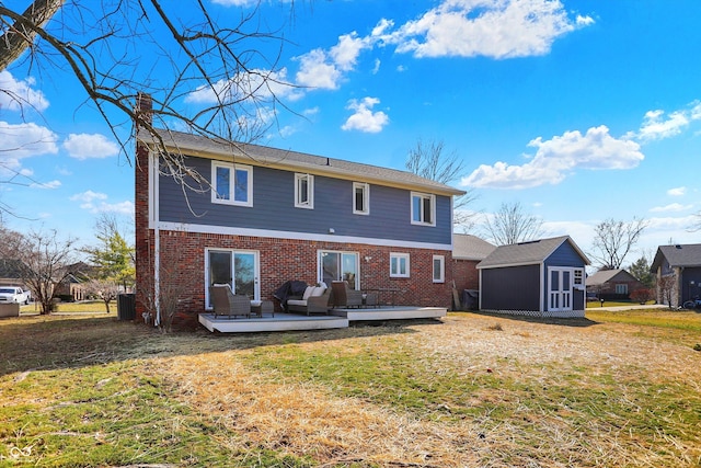 rear view of property with a lawn, a deck, an outdoor structure, brick siding, and a chimney