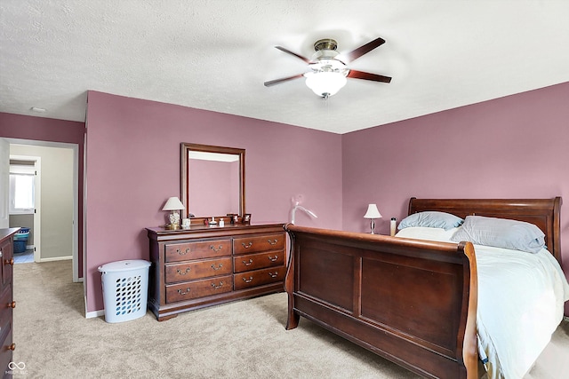 bedroom with a ceiling fan, carpet, baseboards, and a textured ceiling