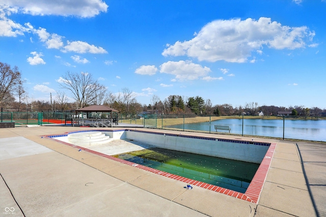 community pool with a gazebo, a patio, a water view, and fence