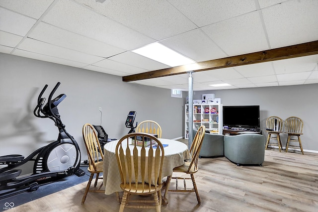 dining room featuring a drop ceiling, baseboards, and wood finished floors