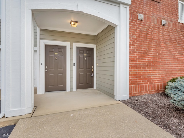 entrance to property featuring brick siding