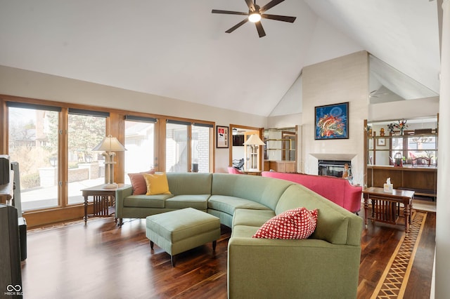 living area featuring ceiling fan, dark wood-style floors, high vaulted ceiling, and a glass covered fireplace