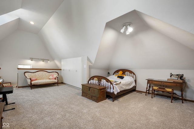 carpeted bedroom with baseboards and vaulted ceiling