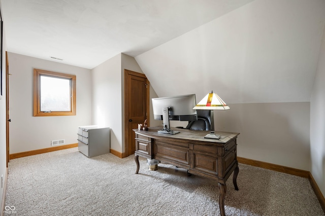 office space featuring visible vents, carpet floors, baseboards, and vaulted ceiling