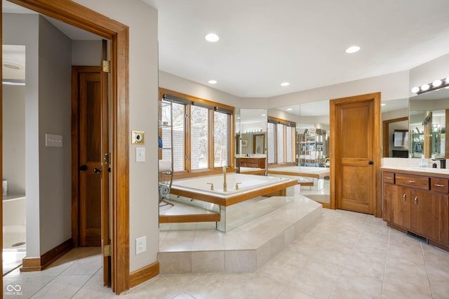 bathroom featuring recessed lighting, tile patterned flooring, baseboards, a bath, and vanity