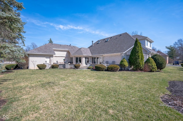 back of property featuring brick siding, a patio, and a yard