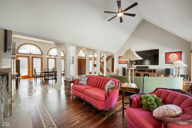 living area with decorative columns, high vaulted ceiling, wood finished floors, and a ceiling fan