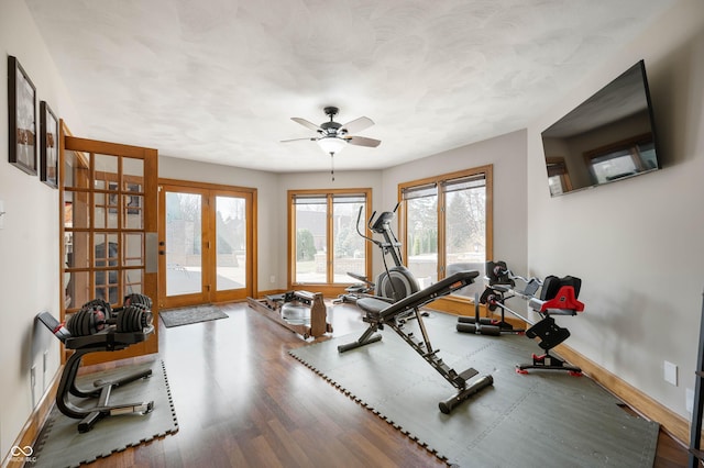 workout room with ceiling fan, french doors, baseboards, and wood finished floors