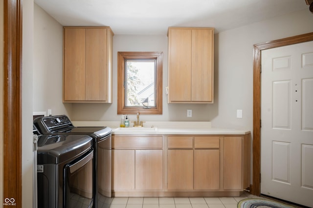 laundry room with cabinet space, washing machine and dryer, and a sink