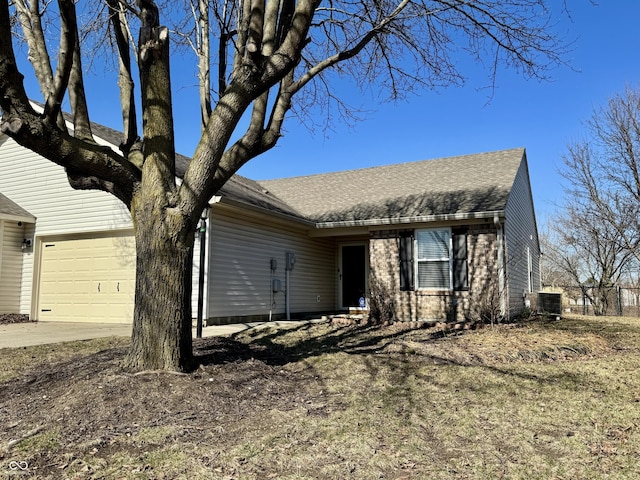 ranch-style house featuring concrete driveway, a garage, and roof with shingles