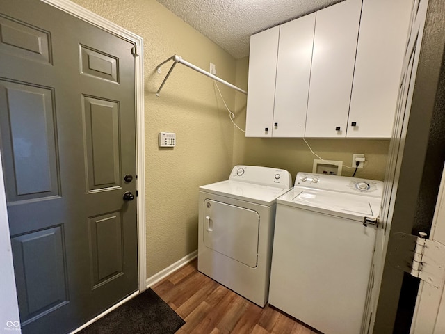 washroom featuring wood finished floors, cabinet space, a textured ceiling, washer and dryer, and a textured wall