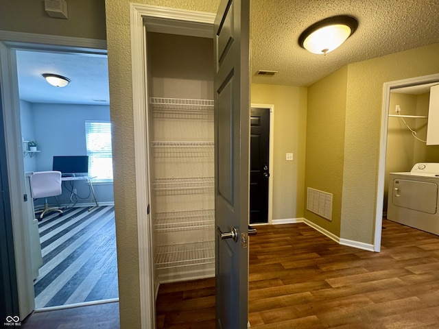 interior space featuring visible vents, washer / clothes dryer, dark wood-type flooring, and a textured ceiling