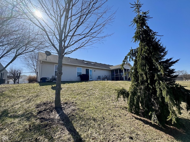 view of property exterior with a yard, fence, and a sunroom