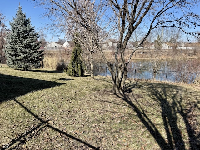 view of yard featuring a water view and fence