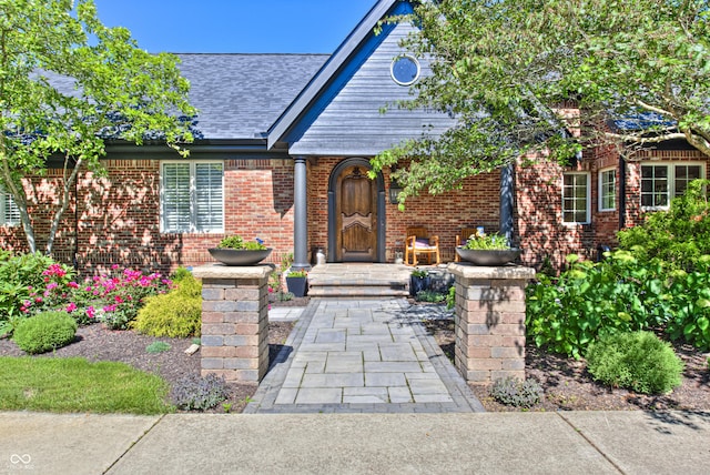 property entrance with brick siding and roof with shingles