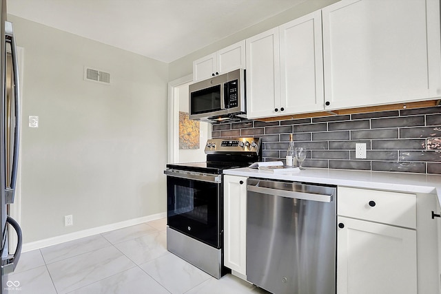 kitchen with visible vents, white cabinetry, appliances with stainless steel finishes, light countertops, and decorative backsplash