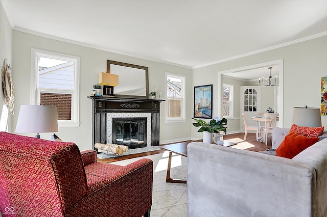 living area featuring crown molding, baseboards, a chandelier, a fireplace with flush hearth, and wood finished floors