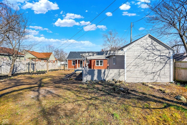 rear view of property with brick siding and fence