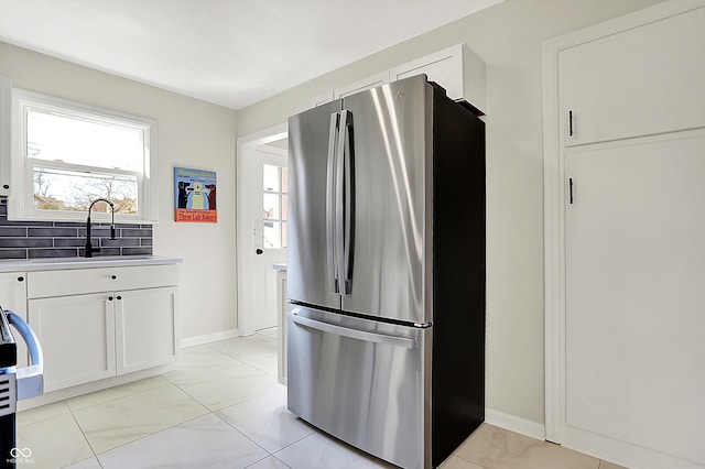 kitchen with a sink, plenty of natural light, white cabinets, and freestanding refrigerator